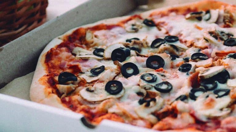 Pizza casera con trufa negra, rúcula y Aceitunas negras en rodajas